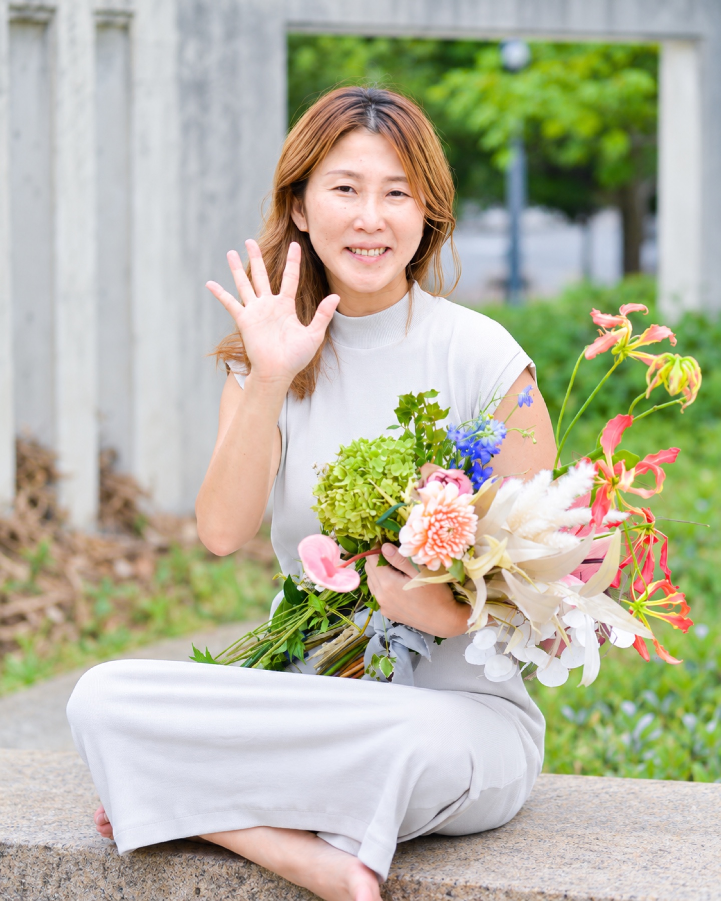 花を手にする朝光哉絵